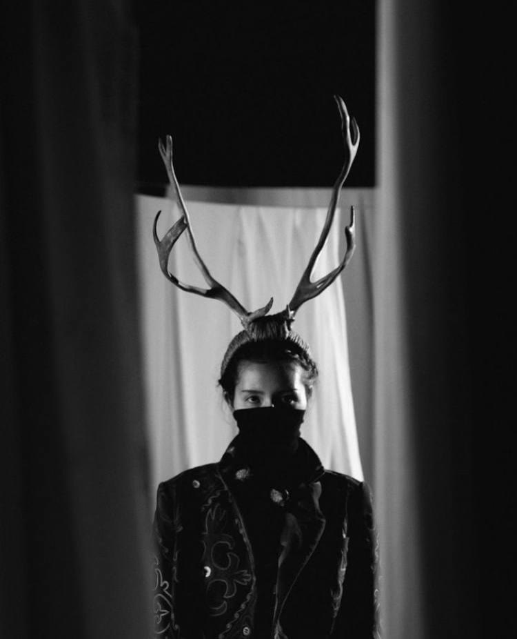 Qoorchaq — veiled figure crowned with deer antlers, black and white